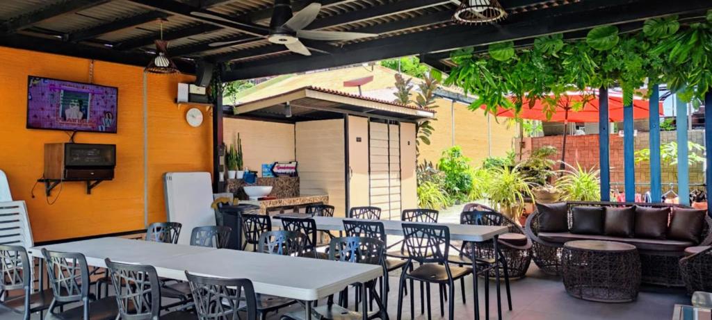 un patio con tavoli, sedie e divano di Exclusive Beachfront House with Pool Batangas 16pax a Lobo