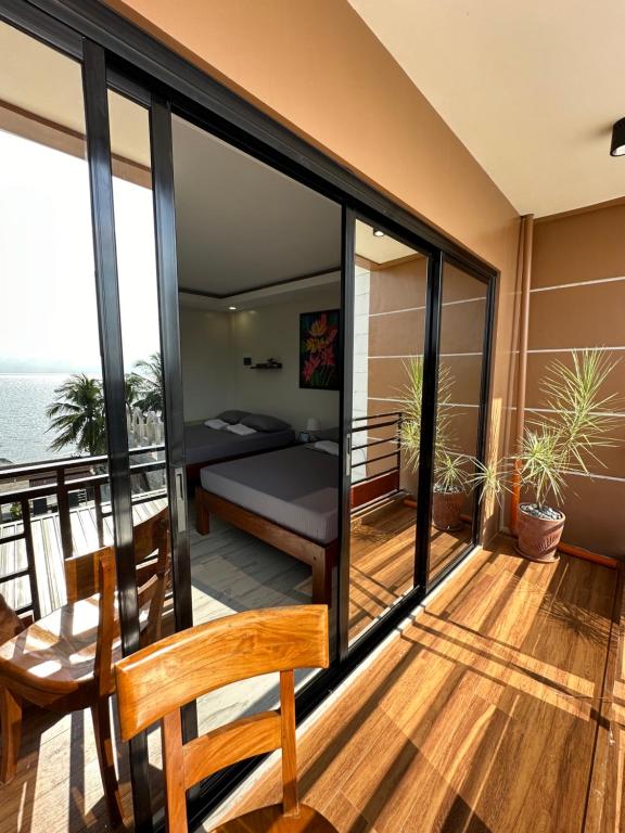 Camera con balcone, letto e tavolo. di Exclusive Beachfront House with Pool Batangas 16pax a Lobo