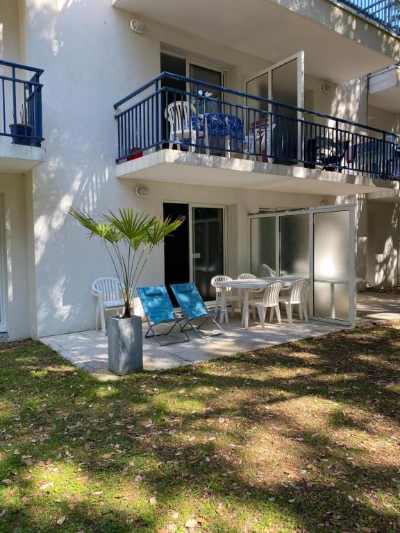 une maison avec un patio avec des chaises et une table dans l'établissement Appart T2 avec coin séparé 2 lits superposés Domaine KER JULIETTE, à Pornichet