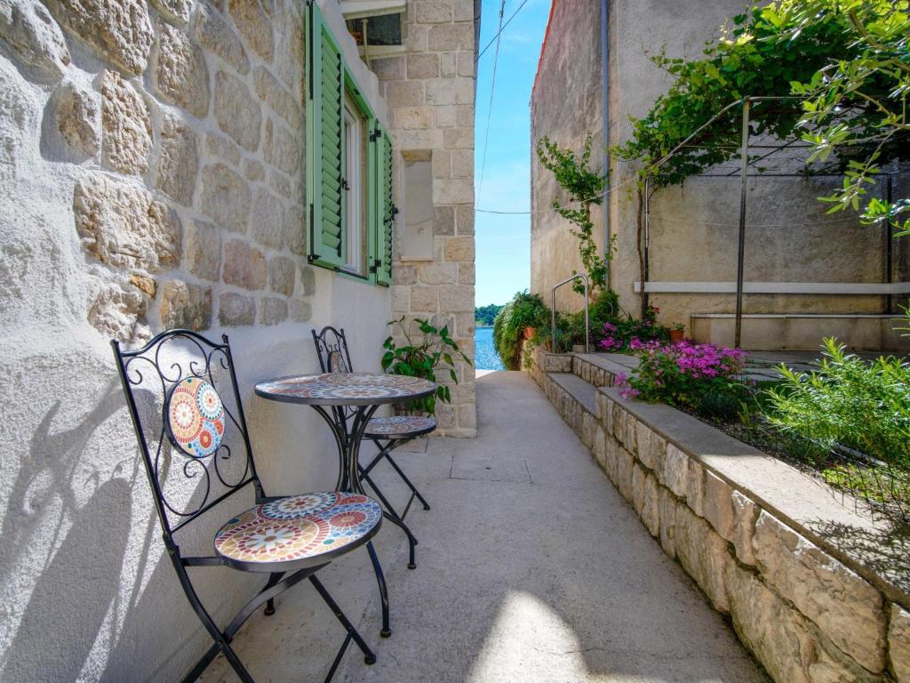 a patio with two chairs and a table and a window at Apartment Rapski dvor by Interhome in Rab