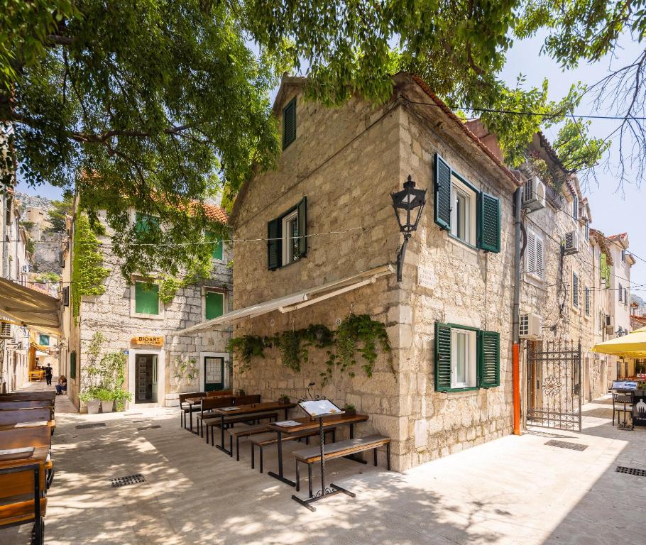 a building with wooden benches in front of it at La Perla - Downtown House in Omiš