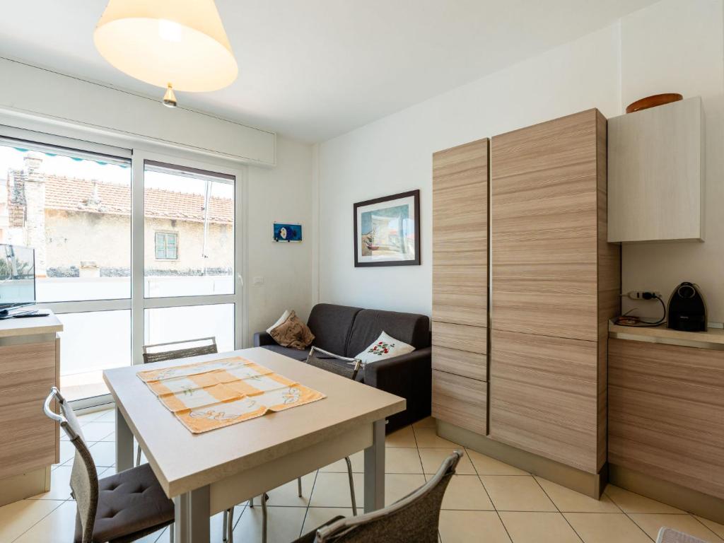 ein Wohnzimmer mit Tisch und Küche in der Unterkunft Apartment Happiness by Interhome in Loano