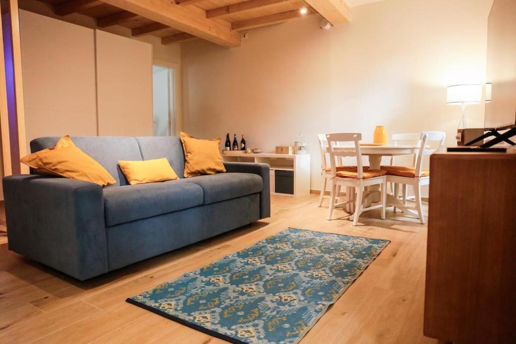 a living room with a blue couch and a table at Good Vibes apartment centro storico Reggio Emilia in Reggio Emilia