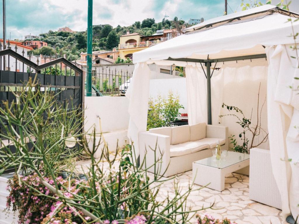 een tuin met witte meubels en een wit bladerdak bij Apartment Wendy by Interhome in Santa Maria Navarrese