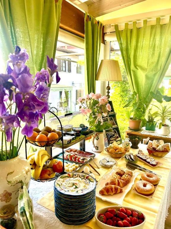 stół z jedzeniem i kwiatami w formie bufetu w obiekcie La Casa Di Campagna Sul Garda w mieście Puegnago