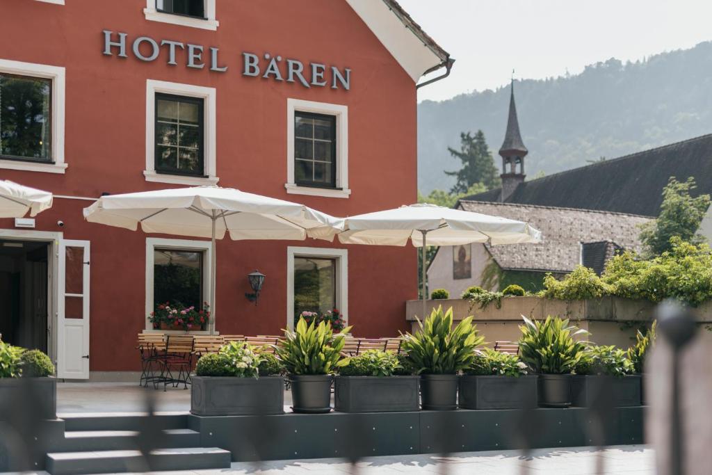 a hotel with umbrellas in front of a building at Hotel Bären in Feldkirch