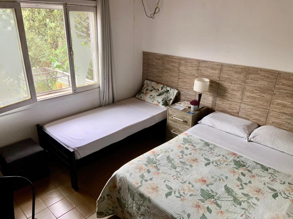 a bedroom with two beds and two windows at Ámbar house apart Iguazú in Puerto Iguazú