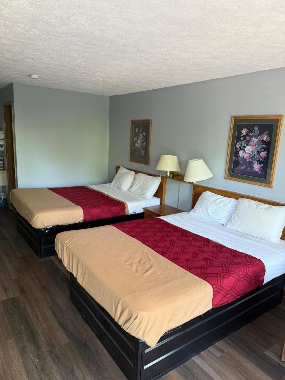 a hotel room with two beds with red sheets at Lakeview Inn in Reeds Spring