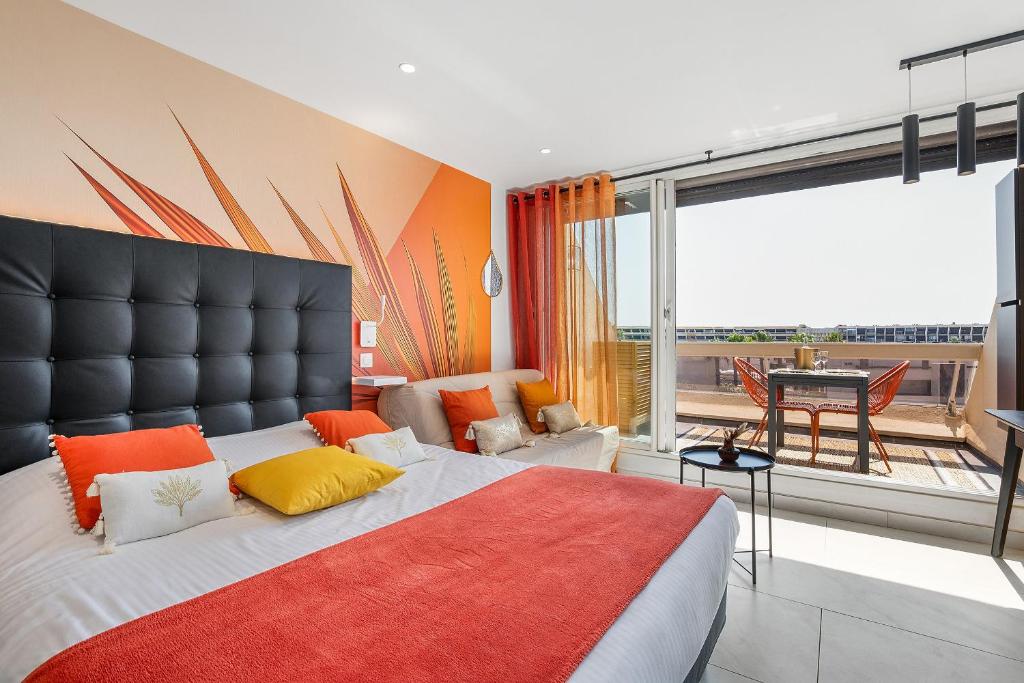 - une chambre dotée d'un grand lit avec des oreillers orange et jaune dans l'établissement Village Naturiste R4N - Will4Stay Sea View, au Cap d'Agde