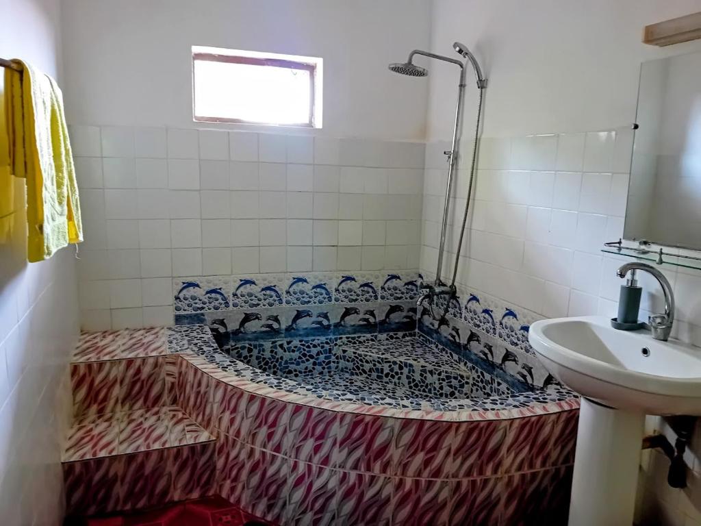 une salle de bain avec une baignoire et un lavabo dans l'établissement Maison avec jardin 3 chambres - Foulpointe - Madasgascar, à Foulpointe