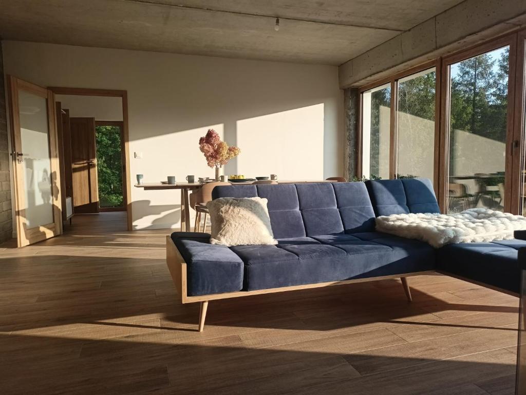 a blue couch in a living room with a table at Warmińska Polana - Nowy, całoroczny dom na 2 ha łące dla 8 osób - Gietrzwałd in Gietrzwałd