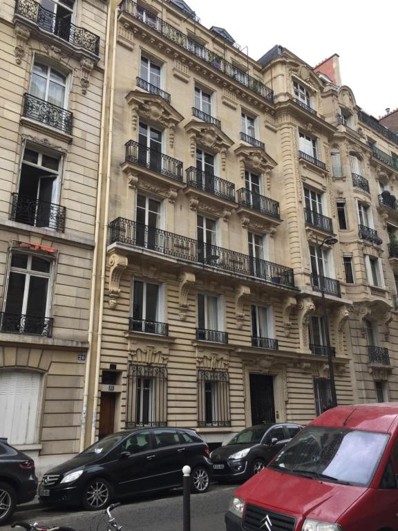 un grand bâtiment avec des voitures garées devant dans l'établissement Studio ETOILE TERNES PAR MONCEAU, à Paris