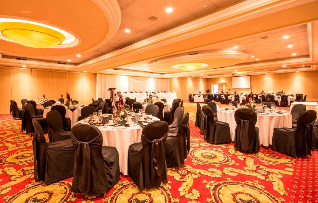 a banquet hall with tables and chairs in a room at Holiday Inn Hotel & Suites St.Catharines-Niagara by IHG in St. Catharines