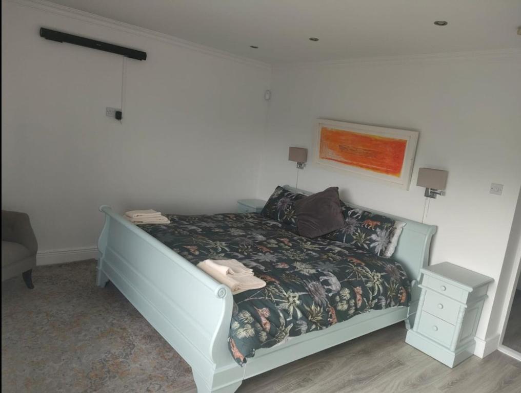 Country Cottage, Stunning Views في ترالي: سرير في غرفة بيضاء مع أغطية السرير غير جيدة في التعامل