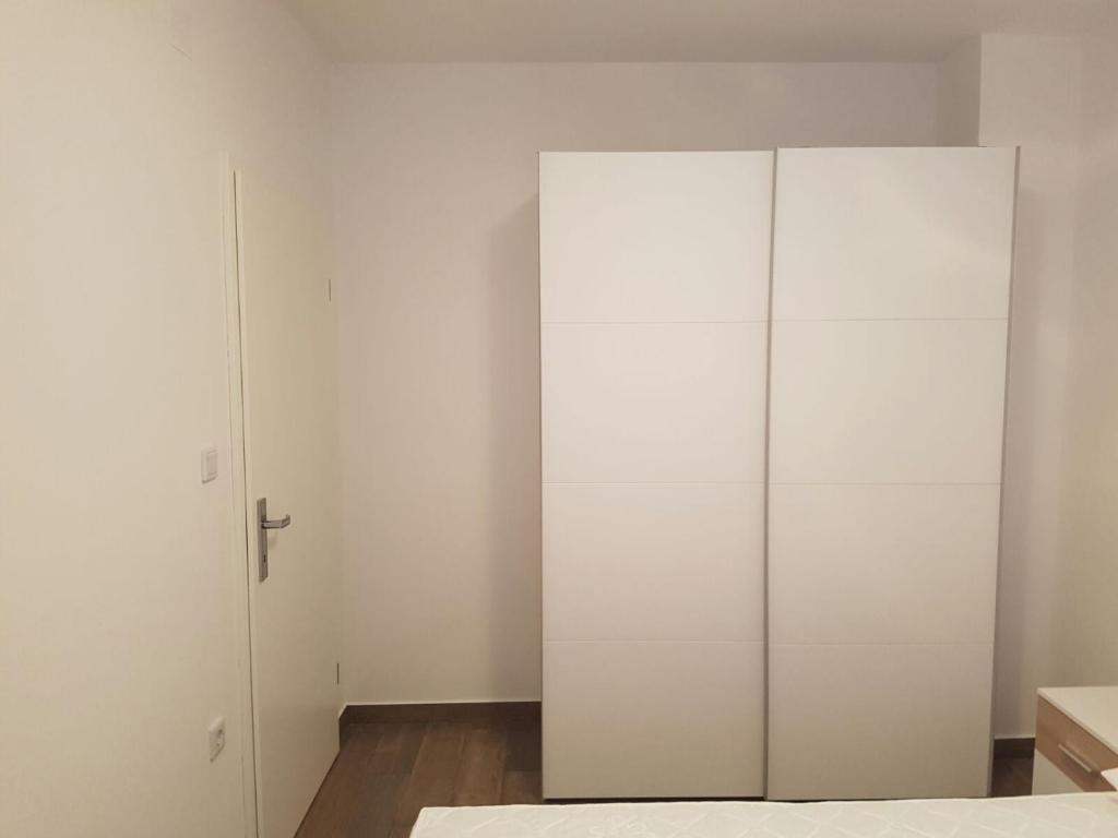 a white wardrobe in a room with a bed at Apartments Tereza in Senj