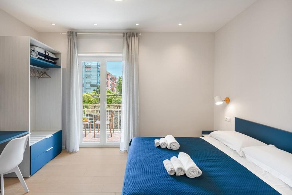 マッサ・ルブレンセにあるMaison le Sirene - Apartmentのベッドルーム1室(ブルーベッド1台、タオル2枚付)