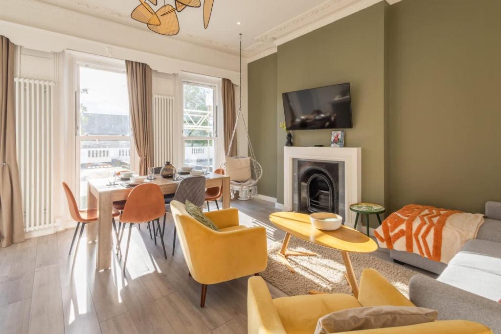 Una sala de estar con un sofá, una mesa y sillas. en Elegant Escape Eastbourne, en Eastbourne