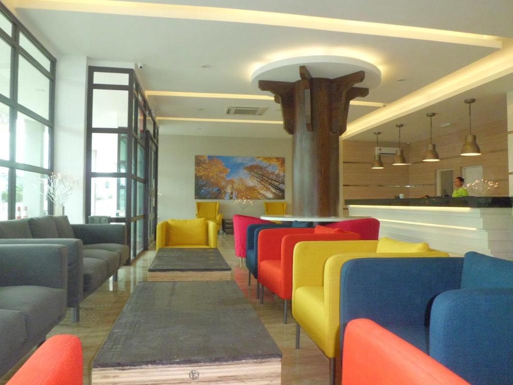 a restaurant with colorful chairs and a bar at The Inn in Bintulu