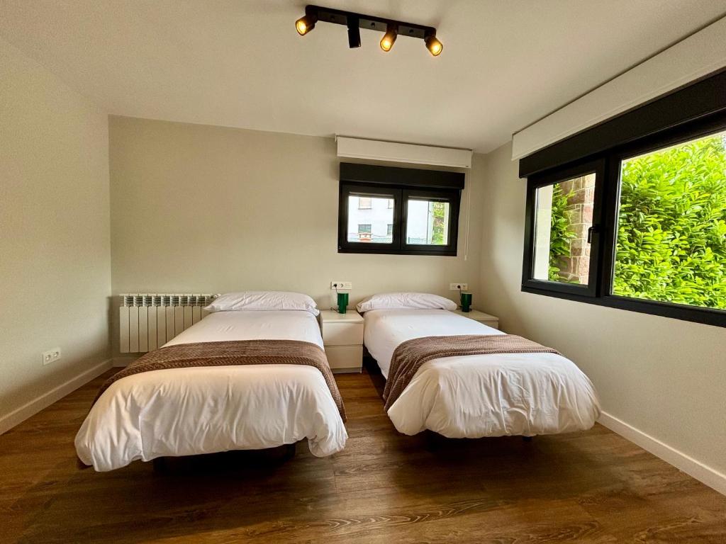 drei Betten in einem Zimmer mit zwei Fenstern in der Unterkunft Vivienda Vacacional El redondu-Roundhouse in Canales