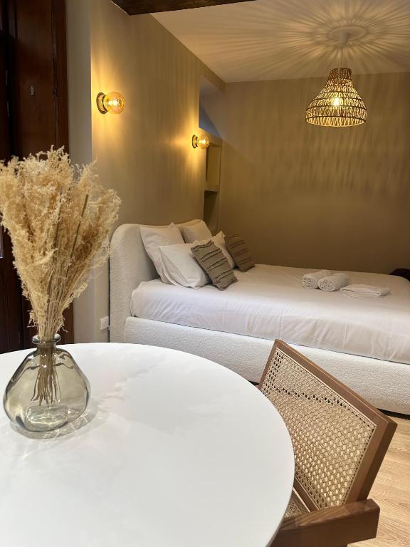 Cette chambre comprend 2 lits et une table ornée d'un vase de fleurs. dans l'établissement Suite by CollectionAura Centre Charleville, à Charleville-Mézières