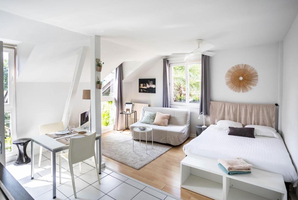 une chambre blanche avec un lit et un bureau dans l'établissement LES MARAICHERS, à Strasbourg