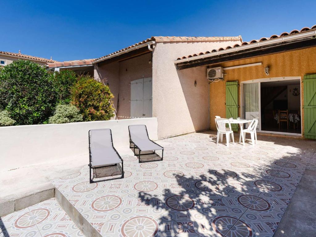 un patio avec des chaises et une table et un bâtiment dans l'établissement Villa pour 6 pers. avec parking et climatisation - FR-1-409-284, à Fleury