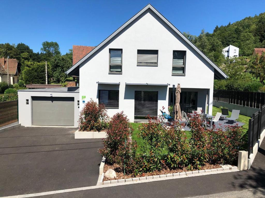ein weißes Haus mit einer Garage und einer Auffahrt in der Unterkunft Maison neuve 4 chambres à Soulzbach - FR-1-744-46 in Soultzbach-les-Bains