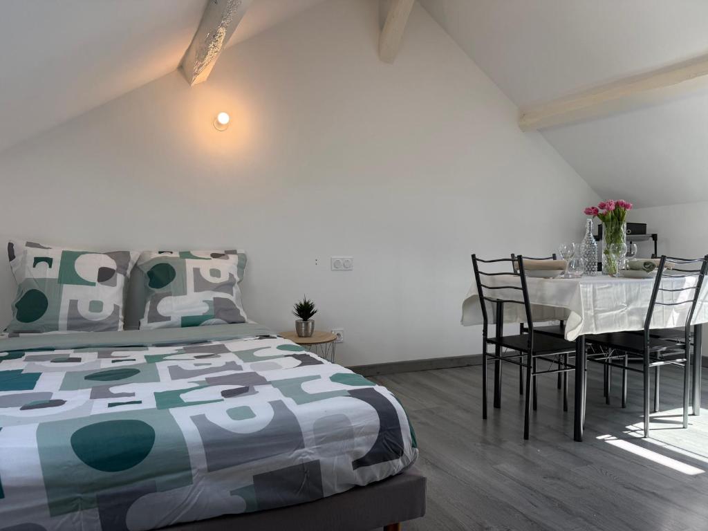 une chambre avec un lit et une table avec des chaises dans l'établissement Studio cosy et rénové près de Périgueux avec Wifi et animaux admis - FR-1-839-4, à Savignac-les-Églises
