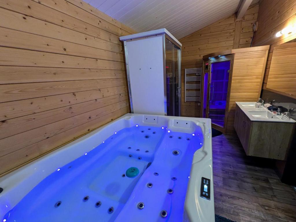 eine Whirlpool-Badewanne im Bad mit Waschbecken in der Unterkunft Chalet détente avec Spa et animaux admis près de Plombières-les-Bains - FR-1-583-498 in La Vaivre