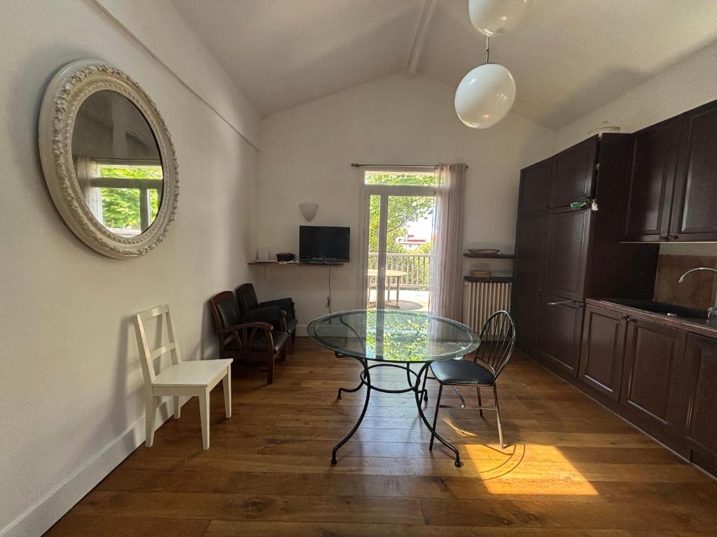 une salle à manger avec une table et des chaises en verre dans l'établissement Charmante maison moderne avec terrasse et parking, cœur de Biarritz - FR-1-239-1132, à Biarritz