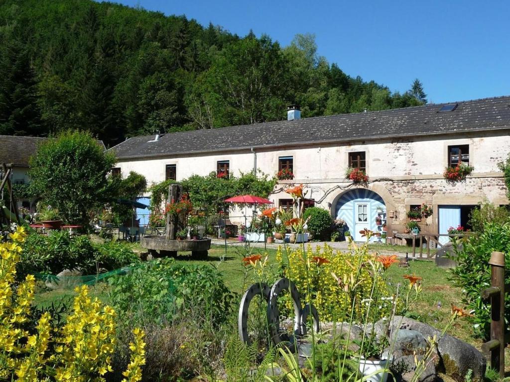a building with a garden in front of it at Charme Authentique au Moulin de Saphoz avec Grand Jardin - FR-1-583-499 in Esmoulières