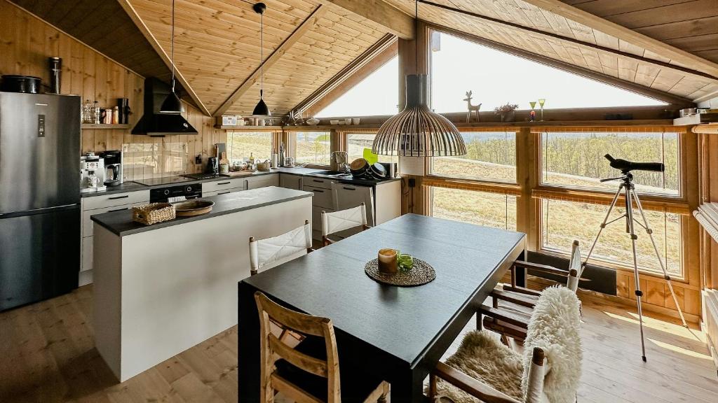 a kitchen with a table and chairs in a house at Cozy Cabin With Fantastic Mountain Views In Oppheimåsen in Torpo
