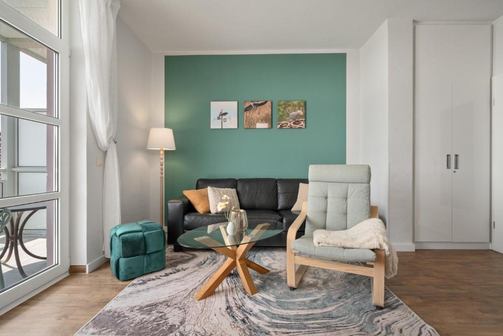 a living room with a couch and a chair at Apartment "Müritzloge" am Stadthafen Waren Müritz in Waren