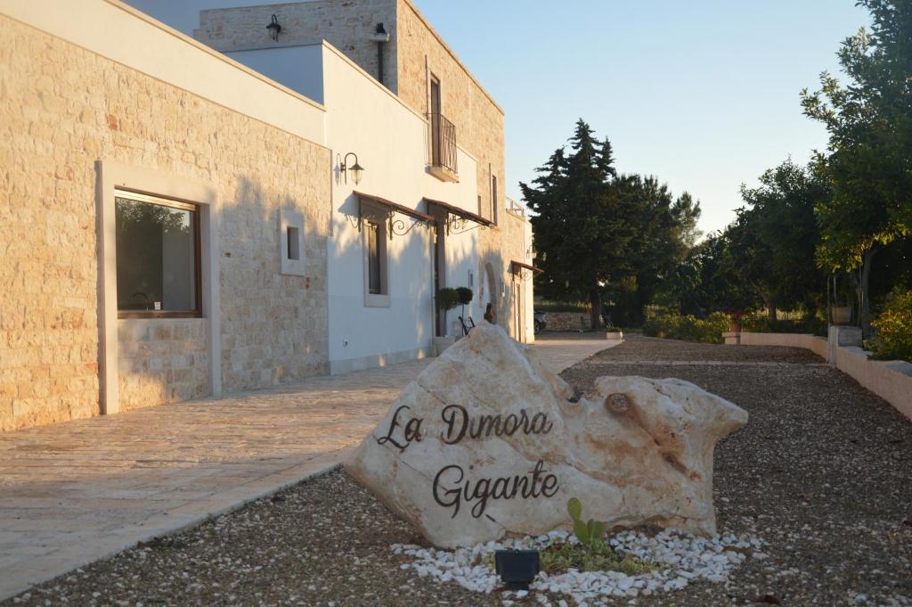 a large rock sitting in front of a building at La Dimora Gigante in Castellana Grotte