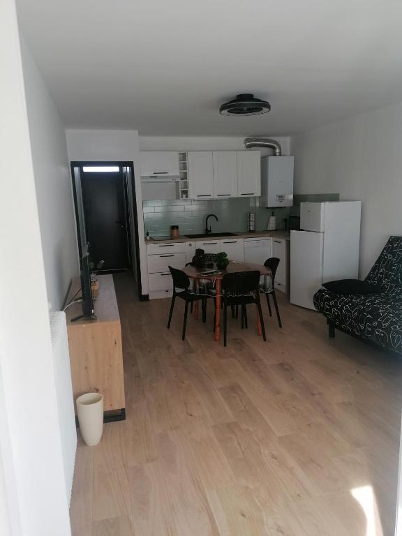 une cuisine et une salle à manger avec une table et des chaises dans l'établissement le miami, à Palavas-les-Flots