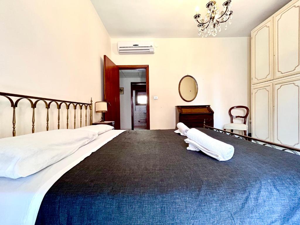 a bedroom with a bed with white sheets and a mirror at Quadrilocale vista mare completamente climatizzato in Gallipoli