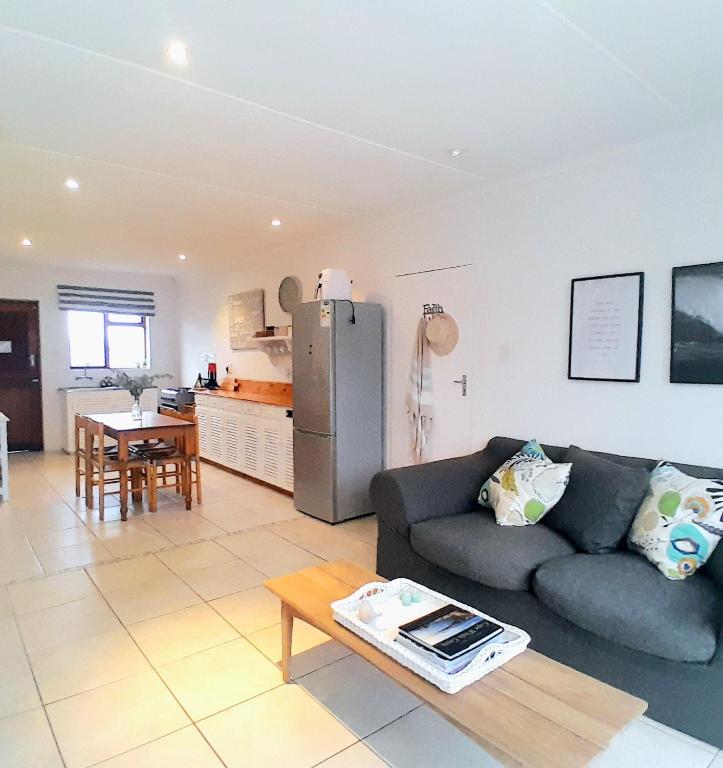 a living room with a couch and a kitchen at Mclaren Self Catering in Gansbaai