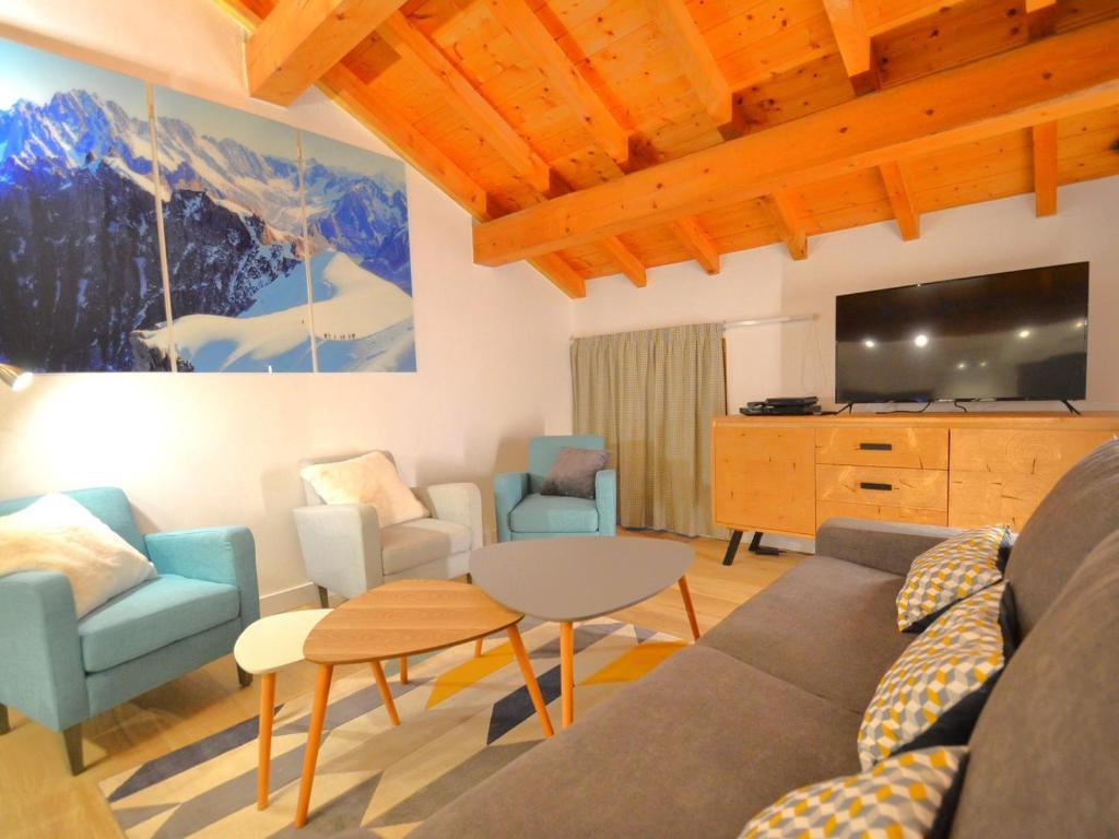 Una sala de estar con un sofá y sillas y un televisor. en Charmant appartement 3 pièces avec parking et wifi à Saint-Martin-de-Belleville - FR-1-452-351, en Saint-Martin-de-Belleville