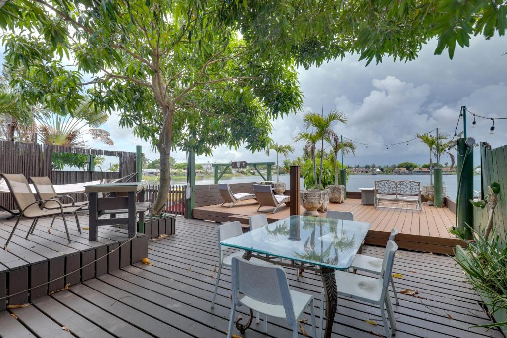 un patio con una mesa de cristal y sillas en una terraza en Lakefront Getaway with Dock Near Las Olas Beach, en Fort Lauderdale