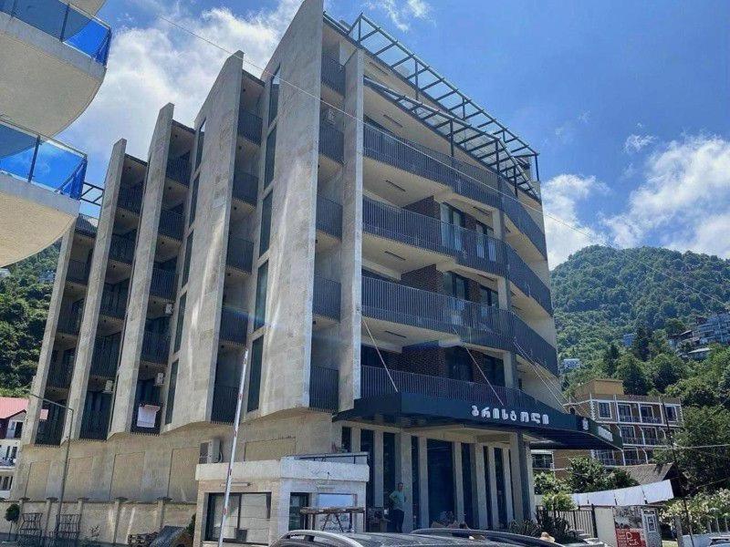 卡瓦拉提Bristol Coco的街道上一座大型建筑,前面有汽车停放