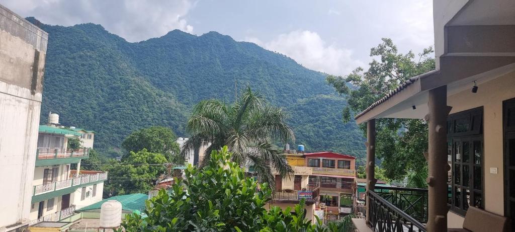 a view of a mountain from a city with buildings at Oslo Ganges by Around stays, Tapovan in Rishīkesh
