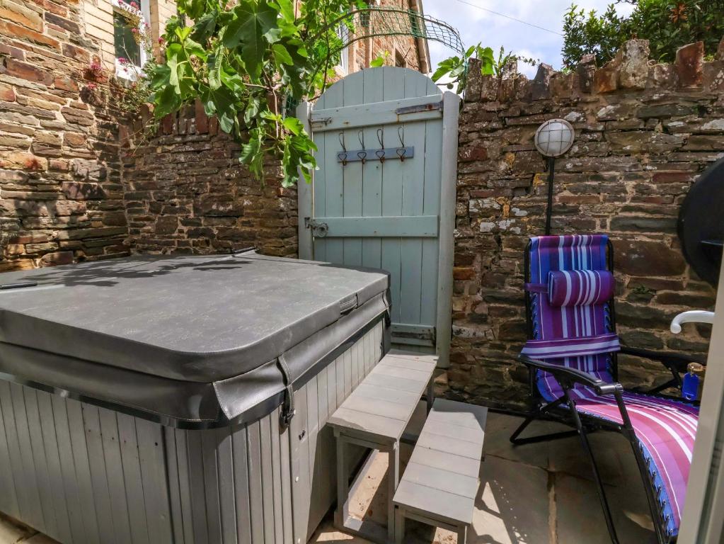 ビデフォードにあるSea Sanctuaryのレンガの壁の横にある温水浴槽と椅子
