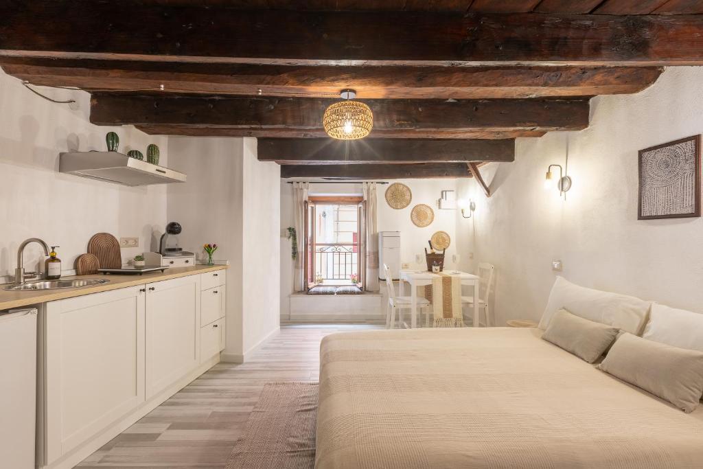 a kitchen and living room with a bed in a room at Arc de San Martí in Alghero