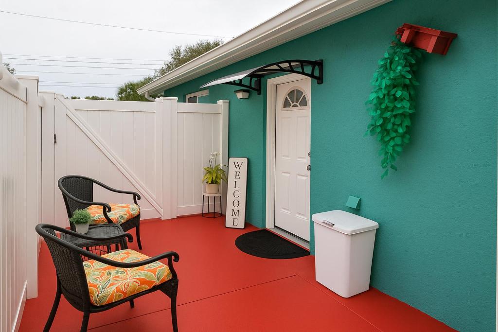 坦帕Green Castle Apartment in Tampa Near Airport and Busch Gardens的一间设有两把椅子和一扇门的墙壁的房间
