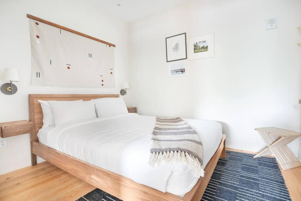 a bedroom with a large white bed with a wooden headboard at Annabelle 2B - City Views near City Market and River in Savannah