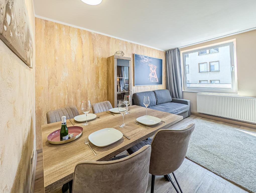 a living room with a table and a couch at H-Lodges - TOP City-Appartments in Essen in Essen