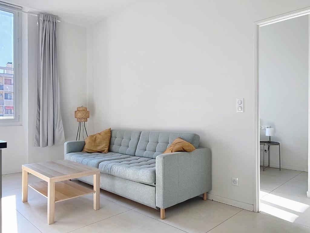 un salon avec un canapé bleu et une table dans l'établissement Cosy climatisé Quartier Endoume, à Marseille