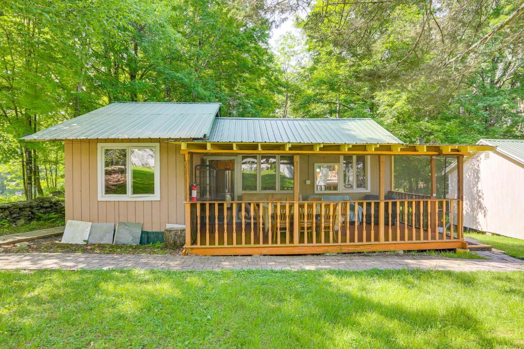 Mongaup Valleyにある5 Mi to Monticello Raceway Cabin Near Shopsの小屋(ベランダ、緑の屋根付)