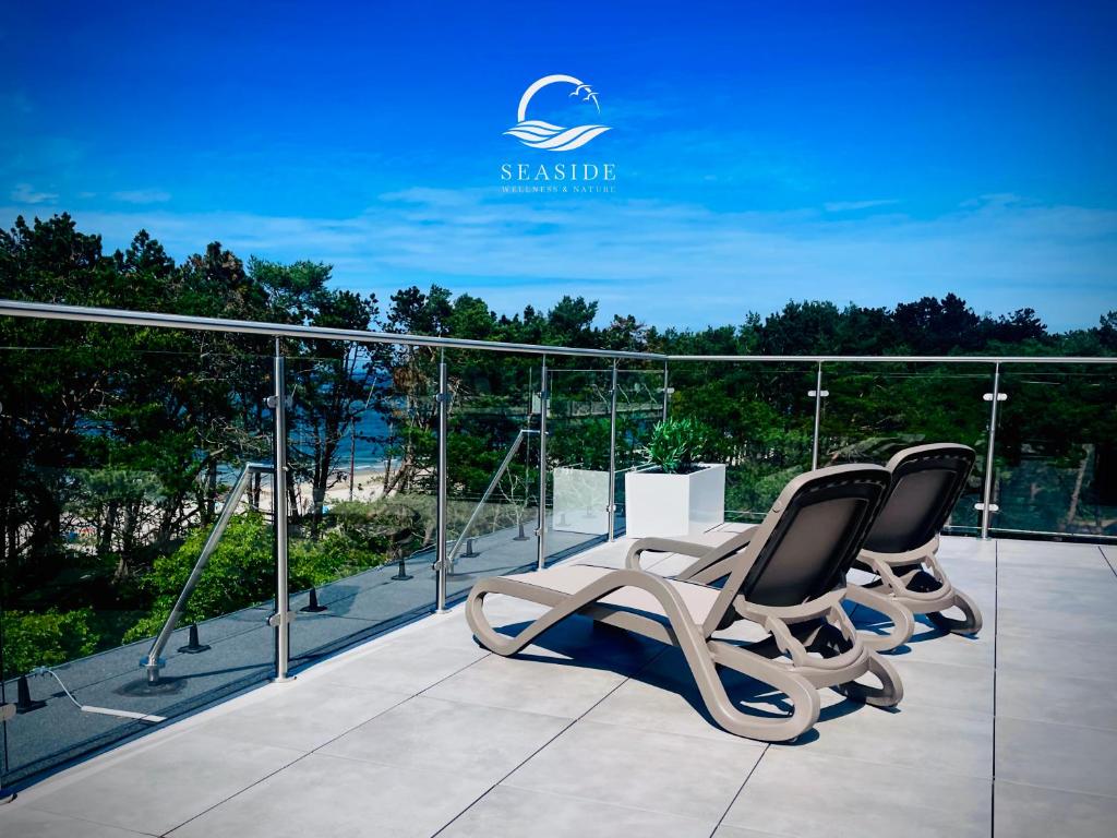 un gruppo di sedie seduto sopra un balcone di Seaside Wellness & Nature - Bezpośrednio przy plaży, Pogorzelica a Pogorzelica