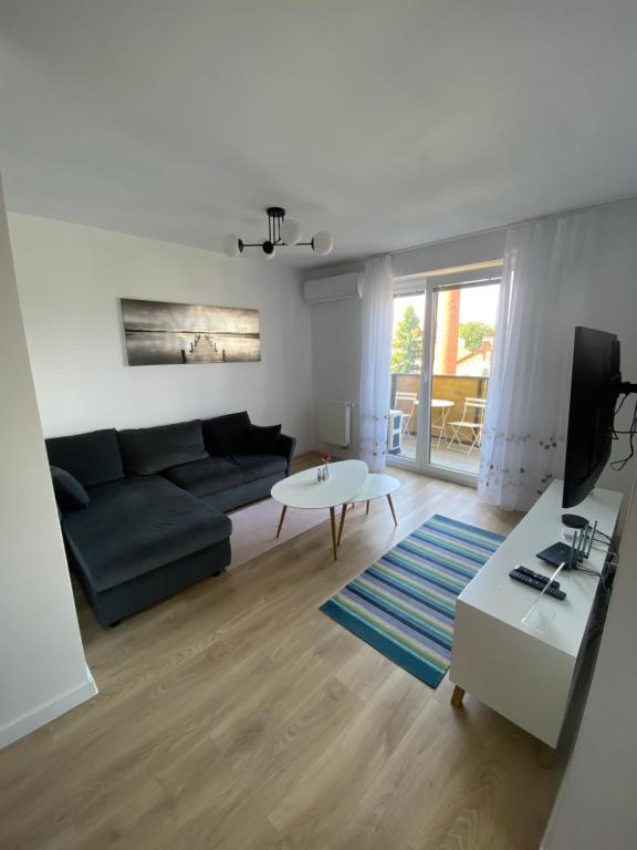 a living room with a couch and a table at City Flat - Garage parking - TRITA SK in Poprad